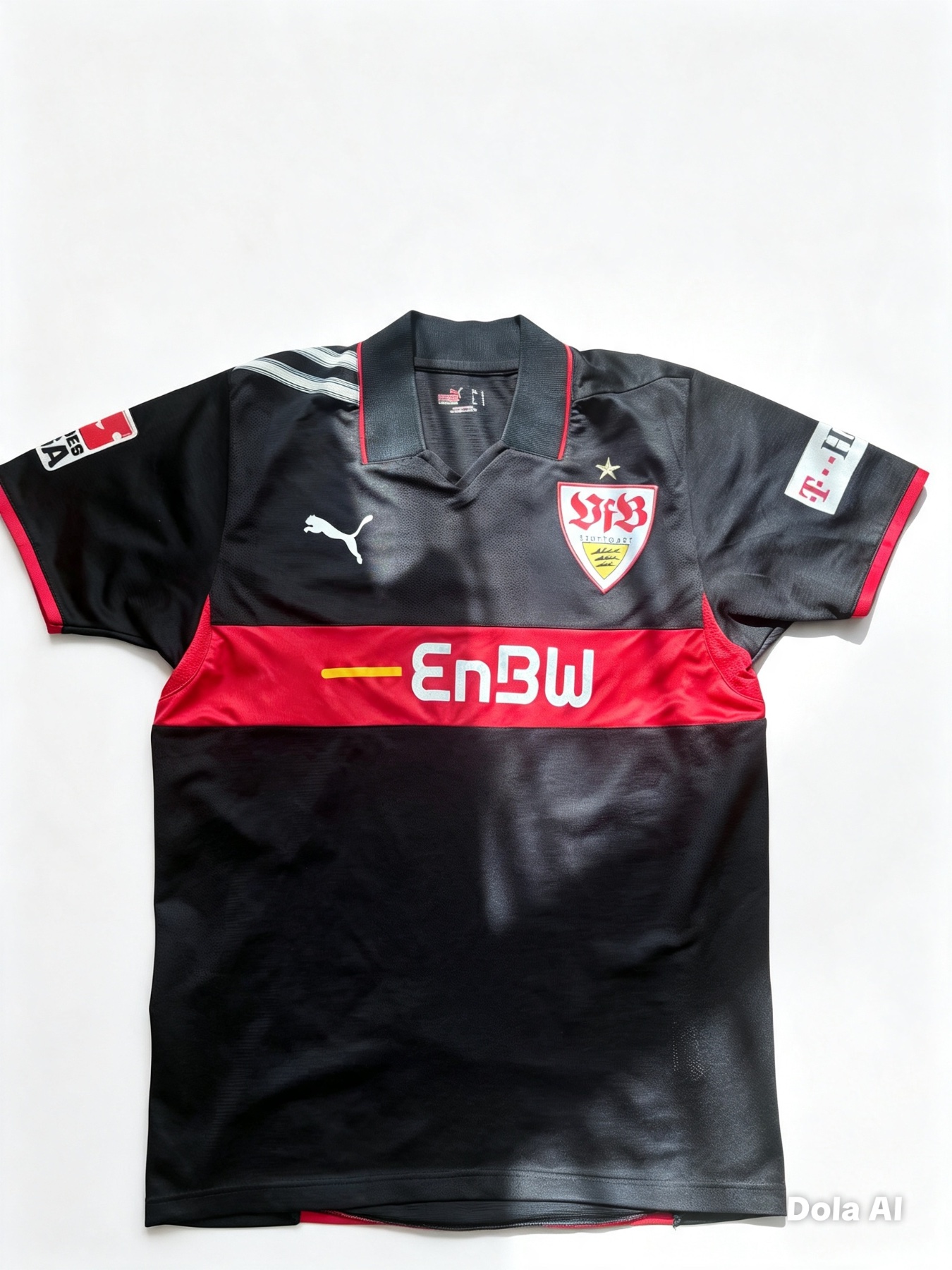 Front of a black VfB Stuttgart jersey featuring a thick red chest stripe with the EnBW sponsor logo, white Puma logo, and a shield-shaped team crest with a gold star